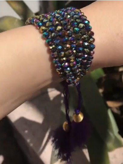 Pulsera UVVA tejida a mano con cristales tornasolados y borlas moradas